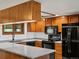 Updated kitchen featuring granite countertops, wood cabinets, and modern black appliances at 3780 W 66Th Ave, Arvada, CO 80003