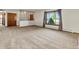Large living room with a window, wooden half-wall, and neutral carpet at 3780 W 66Th Ave, Arvada, CO 80003