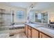 Elegant bathroom with double sinks, granite countertops, a glass-enclosed shower, and a soaking tub at 6268 Pike Ct # D, Arvada, CO 80403