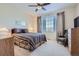Cozy bedroom features a patterned bedspread, ceiling fan, and a window with blinds and curtains at 6268 Pike Ct # D, Arvada, CO 80403