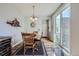 Elegant dining area with a round wooden table, chandelier, and sliding glass door, perfect for gatherings at 6268 Pike Ct # D, Arvada, CO 80403