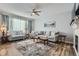 Spacious living room boasts a ceiling fan, large window, and stylish area rug over hardwood floors at 6268 Pike Ct # D, Arvada, CO 80403
