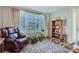 Warm living room with a wooden bookshelf, plants, and a large window, creating an inviting atmosphere at 6268 Pike Ct # D, Arvada, CO 80403