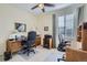 Well-lit office with wood desks, a ceiling fan, and a large window with blinds for a comfortable work environment at 6268 Pike Ct # D, Arvada, CO 80403