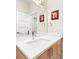 Bathroom featuring a chrome faucet, under sink cabinets, and a large mirror, bright and clean at 3515 S Ogden St, Englewood, CO 80113