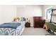 Comfortable bedroom with a twin bed, dark wood dresser, and a view from the window at 3515 S Ogden St, Englewood, CO 80113