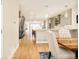 Open-concept dining area with wood floors and sight lines to kitchen and staircase with metal railing at 3515 S Ogden St, Englewood, CO 80113
