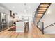 Modern open concept kitchen with an island, stainless steel appliances, and staircase at 3515 S Ogden St, Englewood, CO 80113