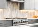 Modern kitchen featuring stainless steel range with decorative backsplash and ample counter space at 3515 S Ogden St, Englewood, CO 80113