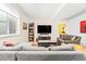 Comfortable living room with a gray sofa, flat screen television, and a window with bars at 3515 S Ogden St, Englewood, CO 80113
