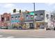 Street view of a gray building with commercial storefronts and prominent street signage at 3515 S Ogden St, Englewood, CO 80113