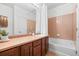 Cozy bathroom featuring tile accent wall, a tub and shower combo, and vanity at 101 Granby Way # B, Aurora, CO 80011