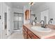 Bright bathroom showcasing a vanity with wood cabinets and a shower behind a glass door at 101 Granby Way # B, Aurora, CO 80011