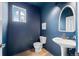 Stylish half bath in a blue tone, featuring a pedestal sink and modern fixtures at 101 Granby Way # B, Aurora, CO 80011