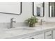 Bathroom vanity featuring double sinks, modern faucets, white cabinets and a small decorative plant at 5763 N Gibralter Way # 2-108, Aurora, CO 80019