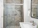 Modern bathroom featuring a tiled walk-in shower with glass door, sleek sink and an oversized mirror at 5763 N Gibralter Way # 2-108, Aurora, CO 80019