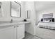 Modern bathroom with a sleek mirror, stylish vanity with a quartz countertop, and a partial bedroom view at 5763 N Gibralter Way # 2-108, Aurora, CO 80019