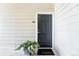 Inviting front door with modern black finish and stylish welcome mat surrounded by lush potted plants at 5763 N Gibralter Way # 2-108, Aurora, CO 80019
