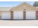Attached garages in a row, with brick accents and classic white garage doors at 5763 N Gibralter Way # 2-108, Aurora, CO 80019