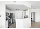 Open kitchen with white cabinets, stainless appliances, breakfast bar, and wood grain vinyl flooring at 5763 N Gibralter Way # 2-108, Aurora, CO 80019
