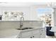 Modern kitchen featuring a stainless sink, tile backsplash, granite countertop, and exterior views at 5763 N Gibralter Way # 2-108, Aurora, CO 80019