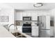 Bright kitchen with stainless appliances, white cabinets, granite countertops, and tile backsplash at 5763 N Gibralter Way # 2-108, Aurora, CO 80019