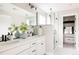 Elegant bathroom featuring a dual vanity, a large mirror, and a glass-enclosed shower with a walk-in closet at 10025 E 63Rd Ave, Denver, CO 80238