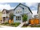Charming two-story home with blue siding, brown trim, and a well-manicured front yard in a suburban neighborhood at 10025 E 63Rd Ave, Denver, CO 80238