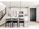 Bright modern kitchen with white cabinets, a center island with bar seating, and stainless steel appliances at 10025 E 63Rd Ave, Denver, CO 80238