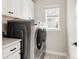 Efficient laundry room with modern washer and dryer units, cabinetry, and ample natural light at 10025 E 63Rd Ave, Denver, CO 80238
