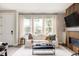 Cozy living room featuring a comfortable white sofa, modern fireplace, and large windows for natural light at 10025 E 63Rd Ave, Denver, CO 80238