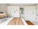 Spacious main bedroom featuring stylish white closets, hardwood floors, and access to the ensuite bathroom at 10025 E 63Rd Ave, Denver, CO 80238