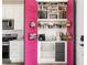Well-organized pantry with bright pink doors, pull-out shelves, and ample storage for kitchen essentials at 10025 E 63Rd Ave, Denver, CO 80238