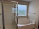 Bathroom with a soaking tub and walk-in shower enclosed by glass, with a window for natural light at 20861 E 40Th Ave, Denver, CO 80249