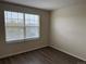 Bedroom with laminate flooring, a large window offering natural light, and neutral wall color at 20861 E 40Th Ave, Denver, CO 80249