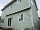 Back exterior featuring green siding, white trim, and multiple windows at 20861 E 40Th Ave, Denver, CO 80249