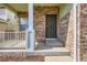 The cozy front porch has a metal security door and brick accents, and a welcoming entrance to the home at 20861 E 40Th Ave, Denver, CO 80249