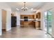 The wide view of kitchen features an island, stainless steel appliances, oak cabinets, and bright modern lighting at 20861 E 40Th Ave, Denver, CO 80249