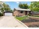 Brick home featuring a detached garage and well-maintained lawn and tasteful landscaping at 11433 Carlile St, Northglenn, CO 80233