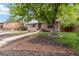 Traditional brick home with mature tree in yard, manicured landscaping, and a walkway at 11433 Carlile St, Northglenn, CO 80233