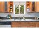 Kitchen sink area with window and views, plus granite counters and wood cabinets at 11433 Carlile St, Northglenn, CO 80233