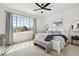 Bright main bedroom with large windows, neutral decor, a ceiling fan, and a comfortable seating area at 871 E 98Th Ave # 1402, Thornton, CO 80229
