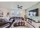 Living room with sectional sofa, large TV, ceiling fan, and accent wall at 1173 Williams Loop, Elizabeth, CO 80107