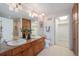 Bathroom featuring double sinks, granite counters, wood cabinets, and a walk-in closet at 1827 N Grant St # 1104, Denver, CO 80203