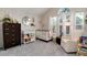 Charming Bedroom with a white crib, a comfortable armchair, and plenty of natural light at 9661 W Chatfield Ave # B, Littleton, CO 80128