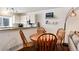 Charming dining area features a round wooden table and seamlessly connects to the adjacent kitchen at 9661 W Chatfield Ave # B, Littleton, CO 80128