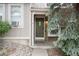 Cozy front porch features a stone accent wall, an olive-green front door and lovely foliage at 9661 W Chatfield Ave # B, Littleton, CO 80128