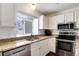 Modern kitchen with stainless steel appliances, granite countertops, and ample sunlight at 9661 W Chatfield Ave # B, Littleton, CO 80128