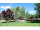 Scenic pond with small bridge, fountain, and mature trees, creating a peaceful outdoor space at 1300 S Parker Rd # 212, Denver, CO 80231
