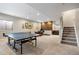 Spacious finished basement offers a ping pong table, and a seating area with a wooden accent wall at 4145 Manorbrier Cir, Castle Rock, CO 80104
